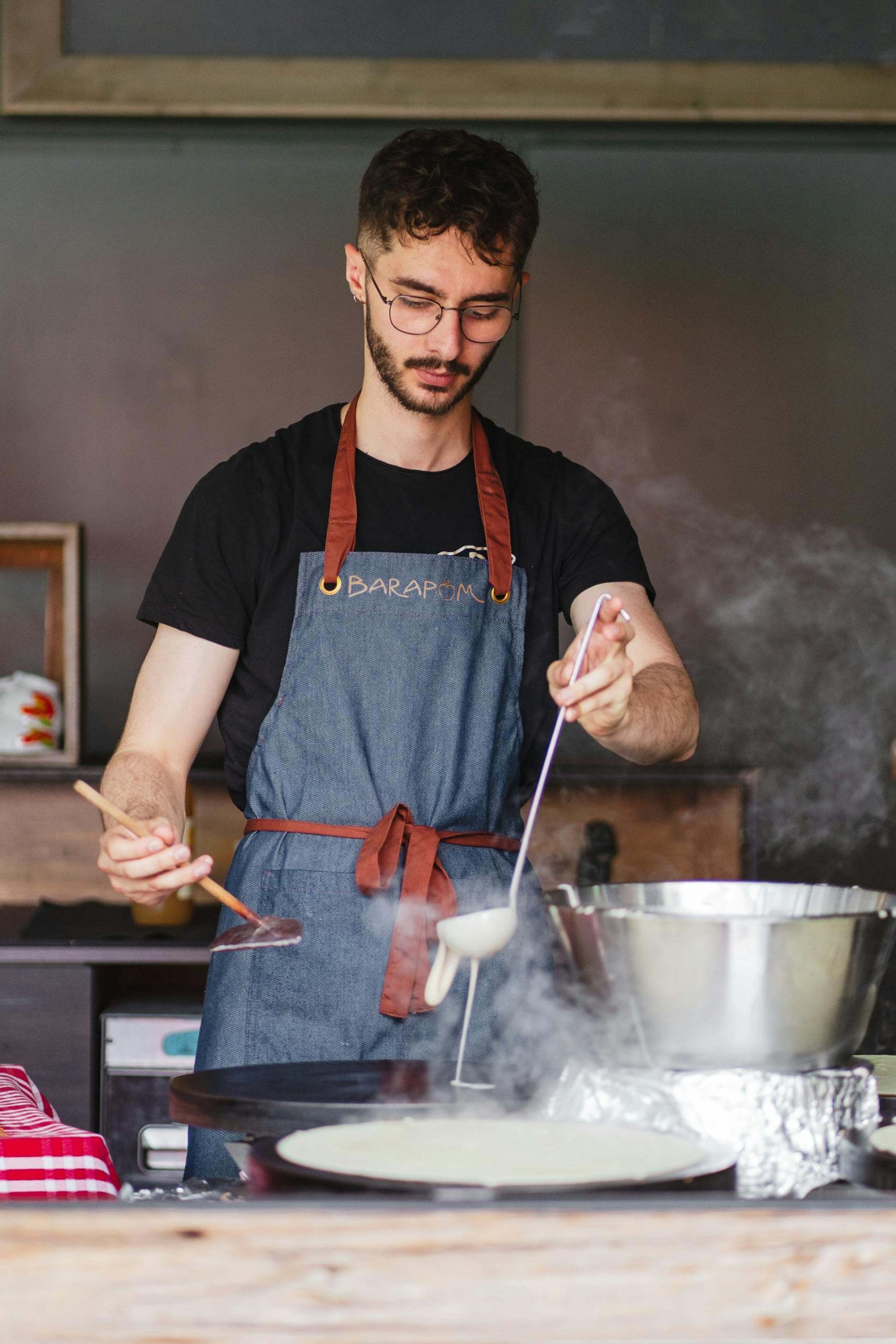 Un homme préparant des crêpes avec un billig